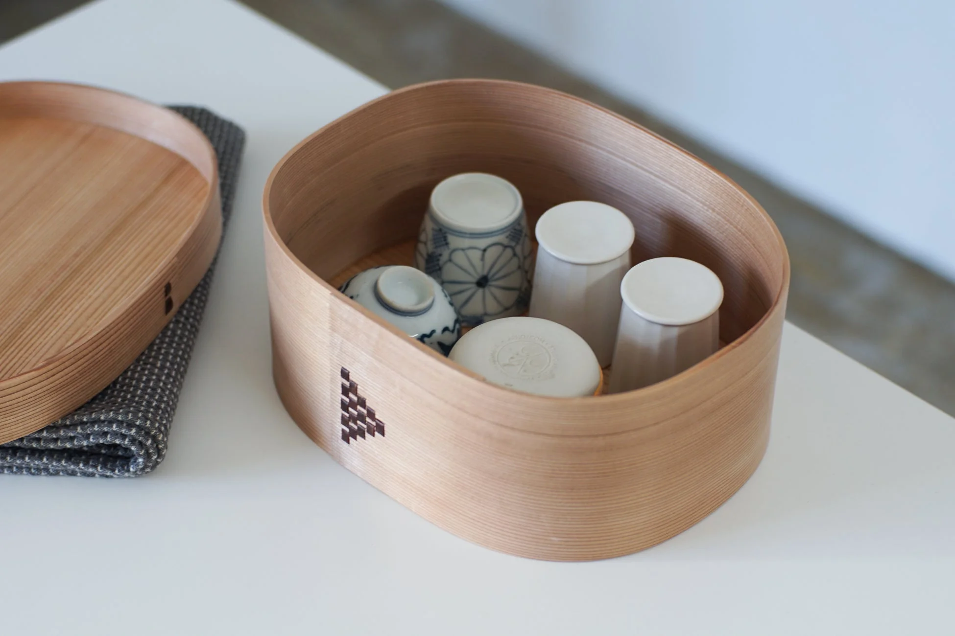 曲げわっぱの木製容器に和食器が収められている