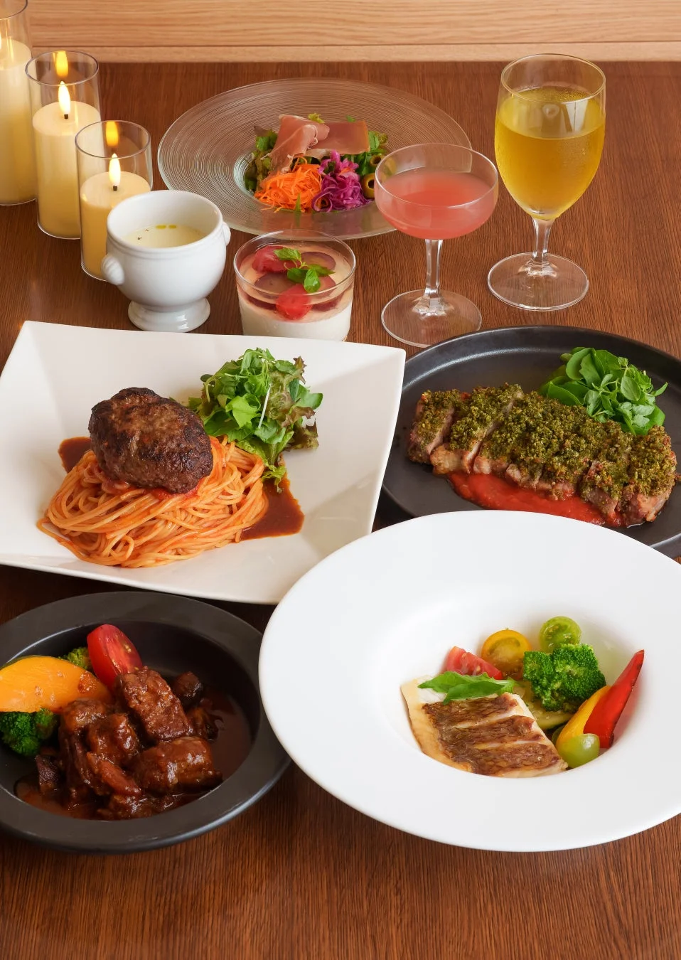 木製のテーブルに並べられた豪華な洋食のコース料理の俯瞰写真