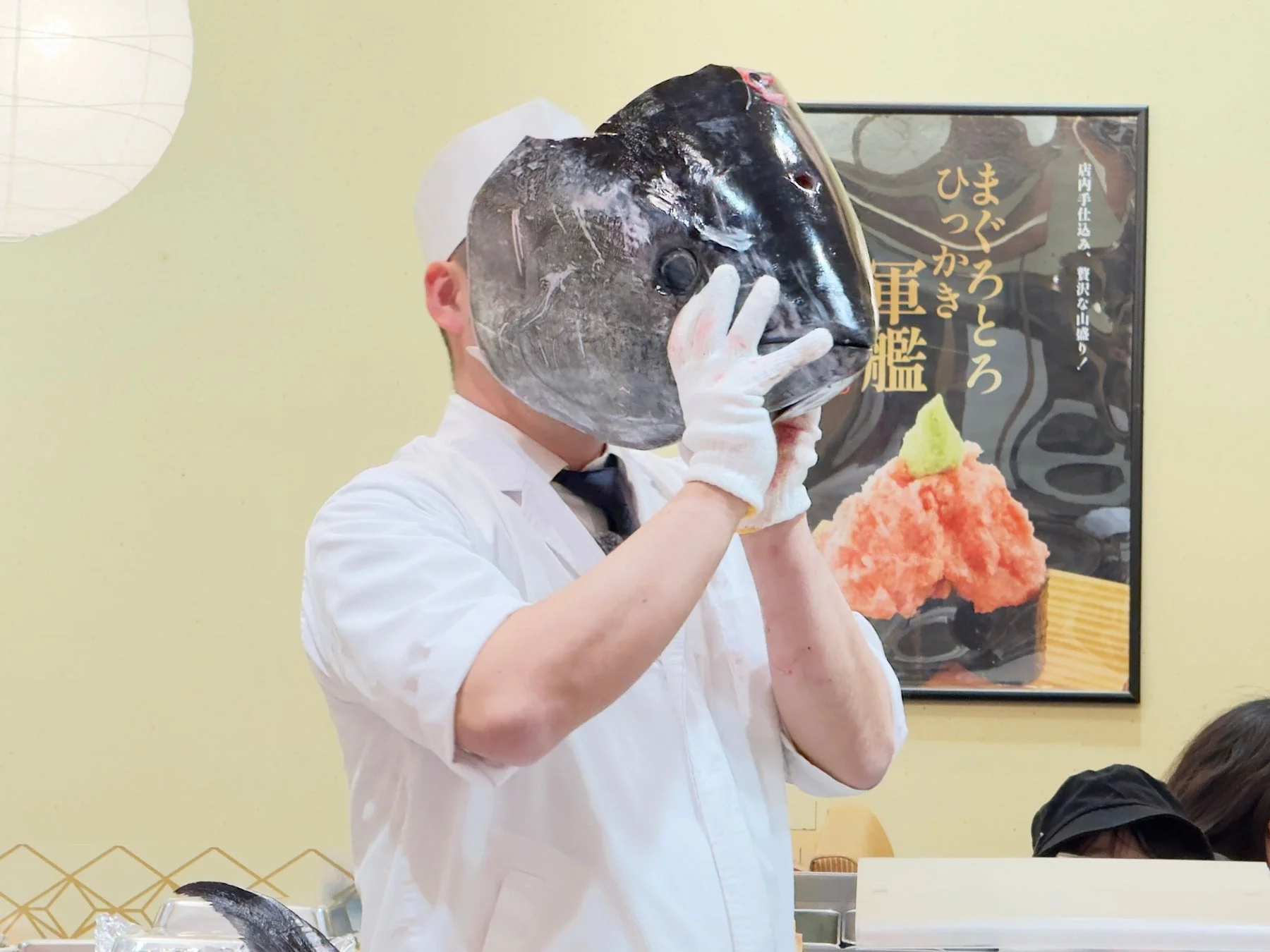 マグロの頭を掲げる職人